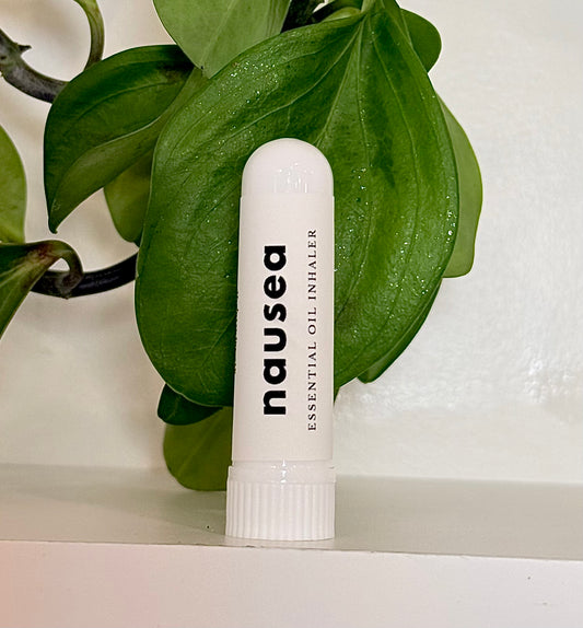 white inhaler tube labeled "nausea" with a plant in the background