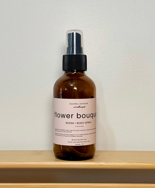 Brown spray bottle labeled 'flower bouquet' on a wooden shelf with a white background