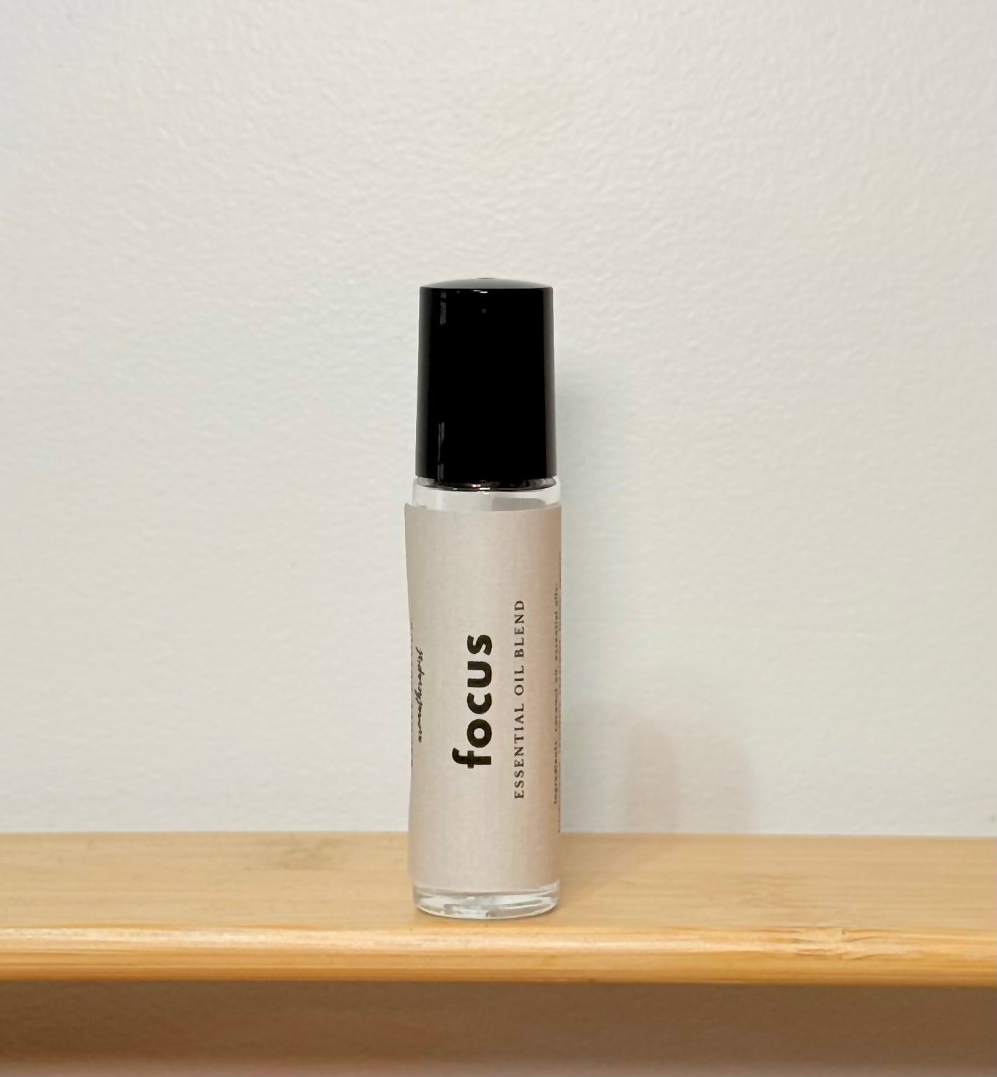 Bottle labeled 'focus' on a wooden surface with a neutral background
