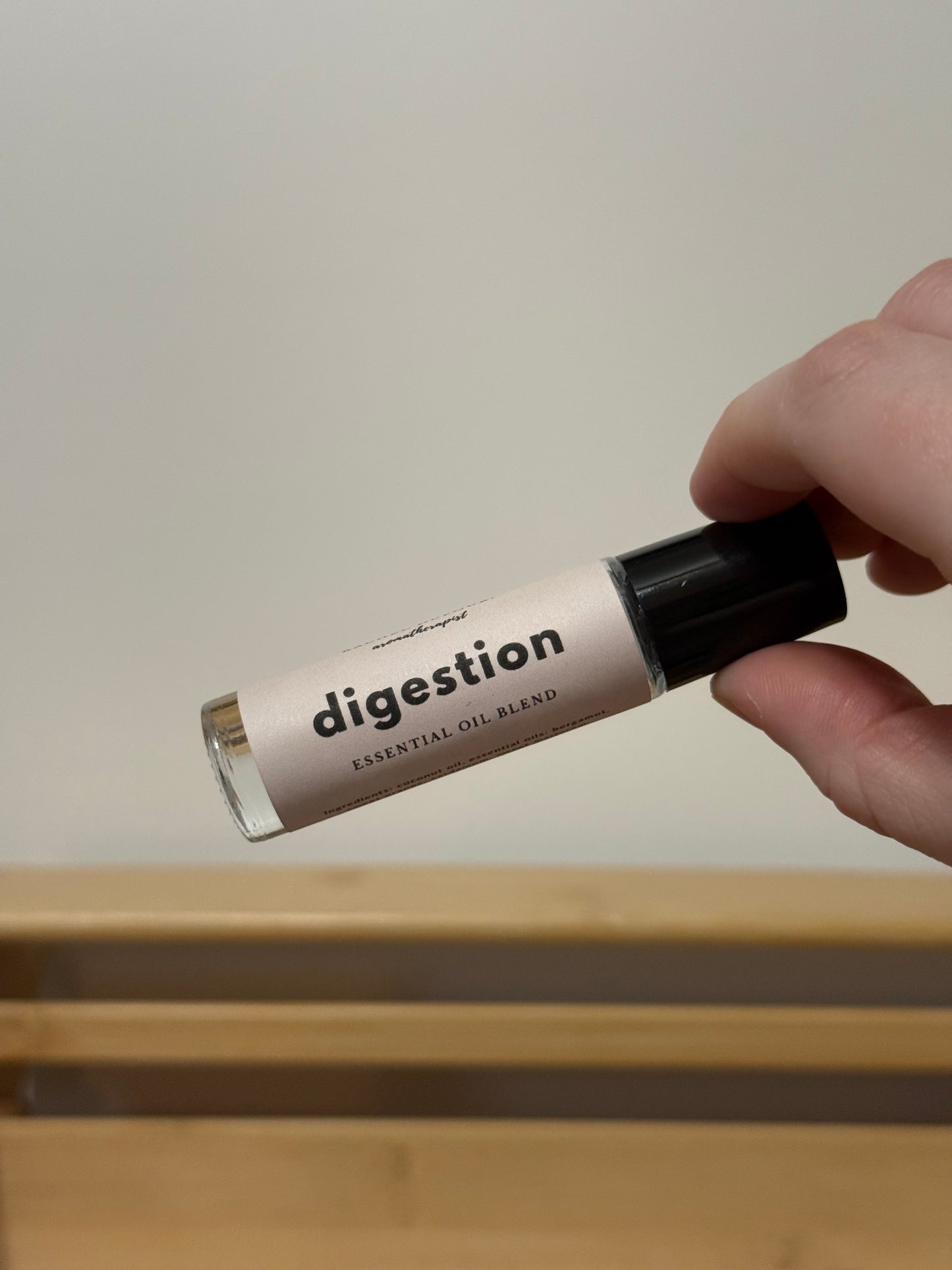 Hand holding a bottle labeled 'digestion' against a neutral background