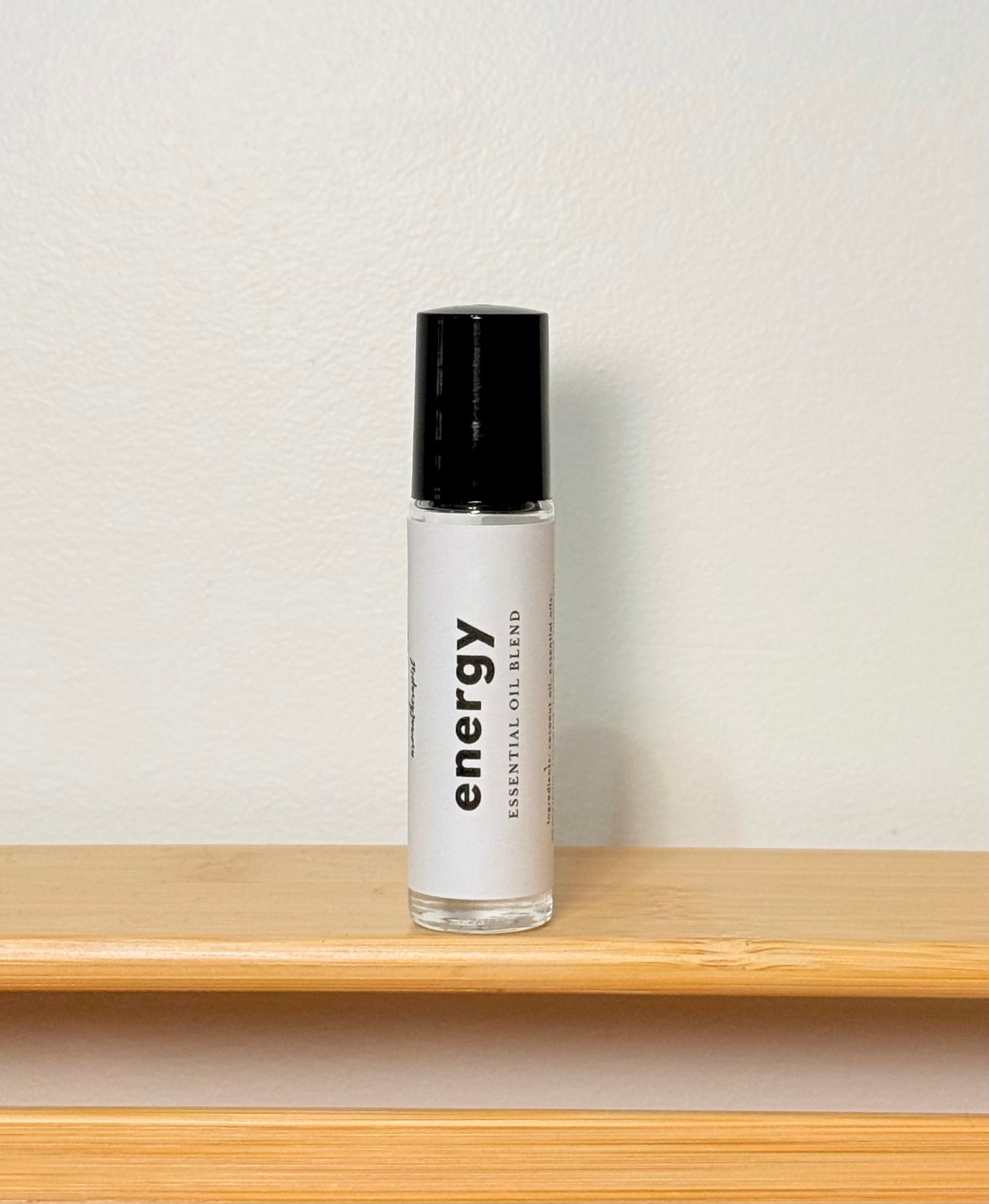 Bottle labeled 'energy' on a wooden shelf with a light gray background