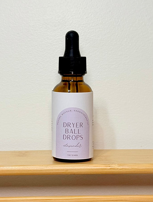 Bottle of dryer ball drops with a dropper on a wooden shelf against a white wall