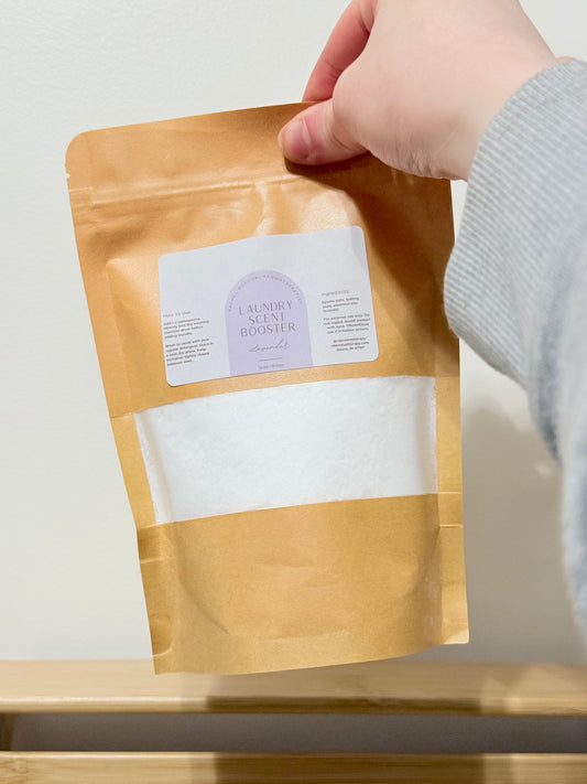 Hand holding a brown paper bag with a label on a light background