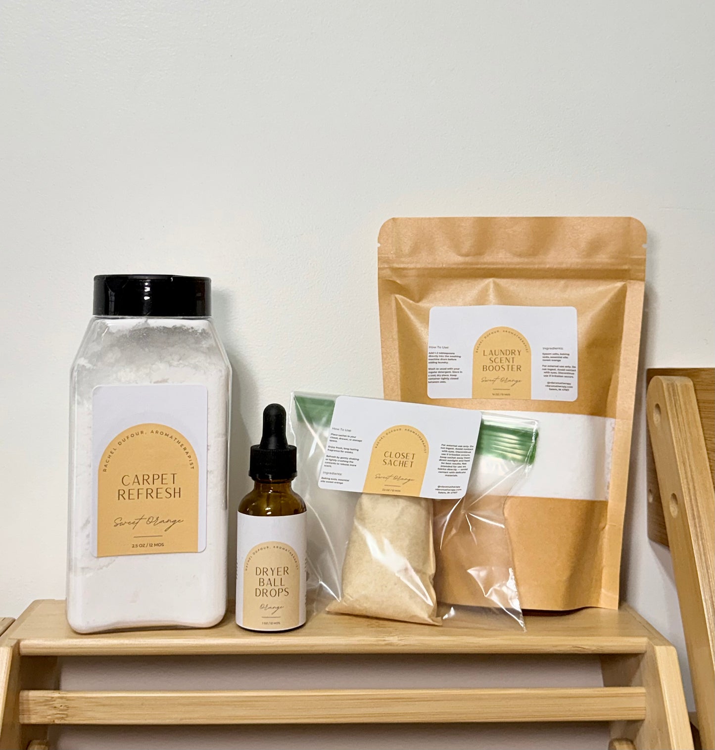Set of cleaning products including a jar, bottle, and bags on a wooden shelf with a white background.