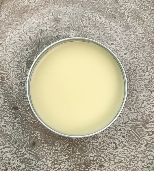 Round container with a white substance on a textured gray surface